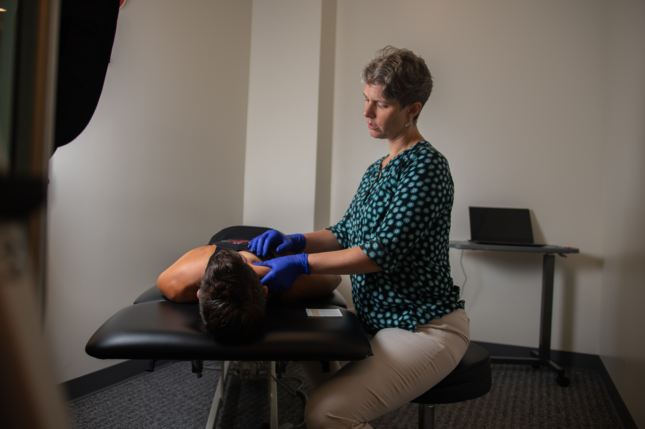 physical therapist preparing shoulder for dry needling